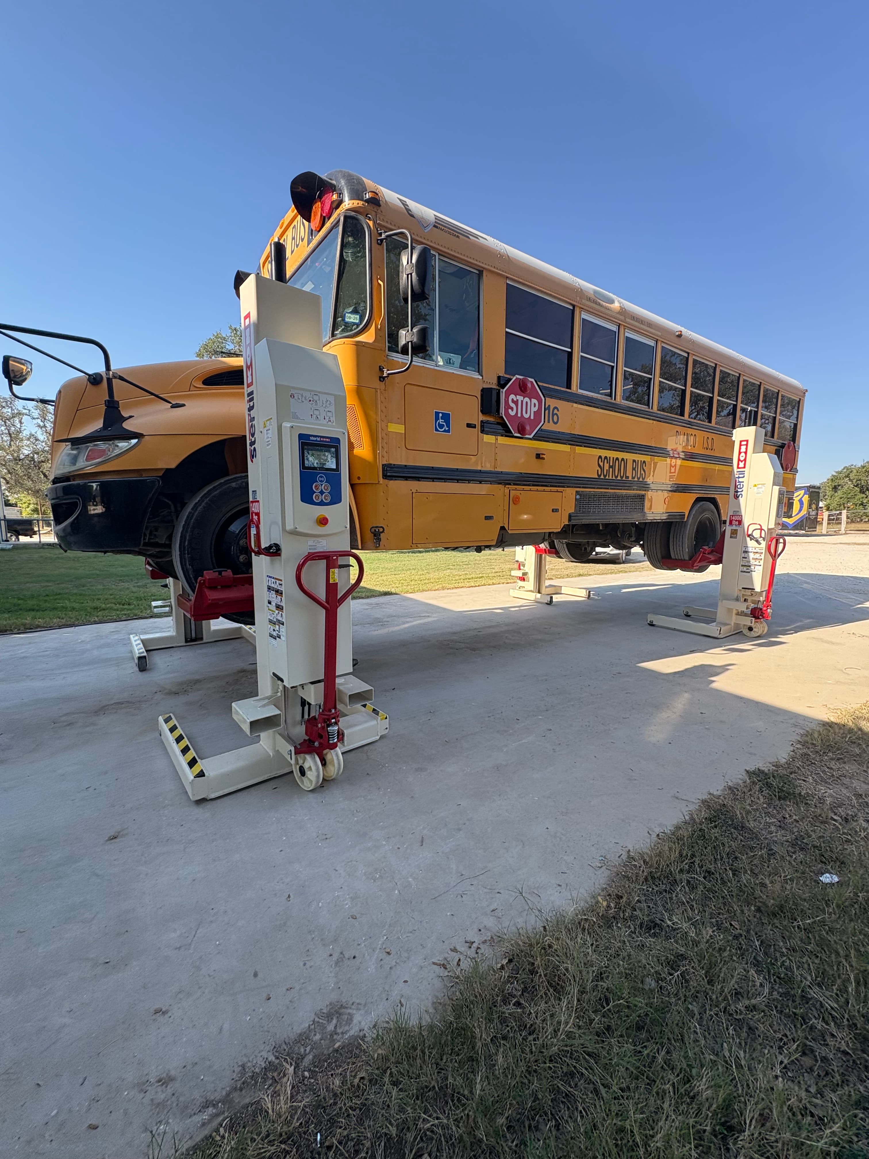 School bus with lift equipment on-site