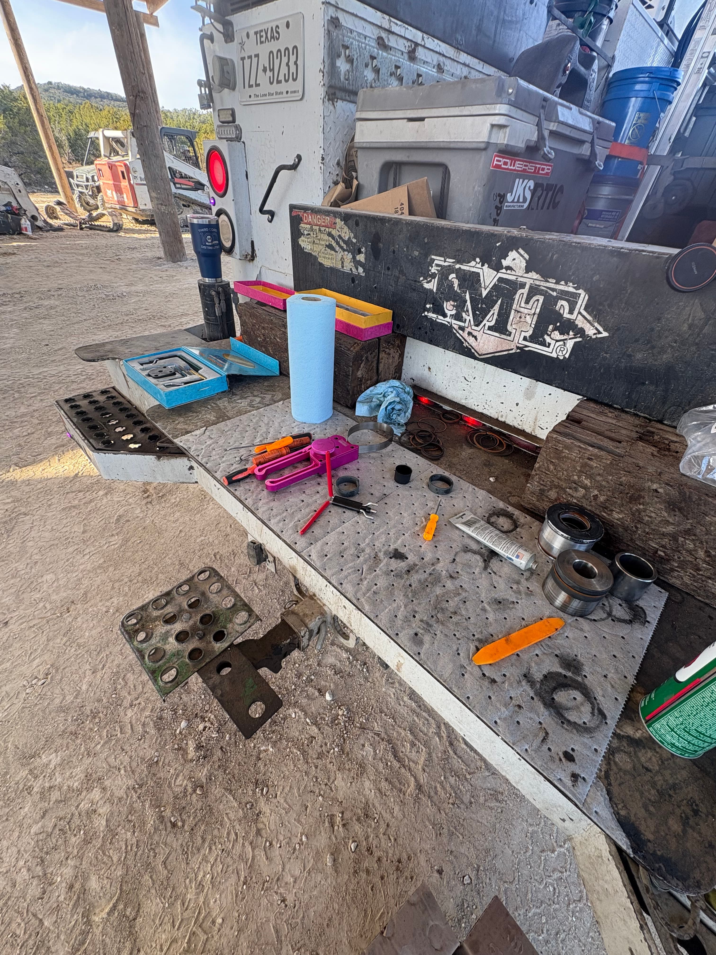 Parts and tools laid out on the service truck tailgate