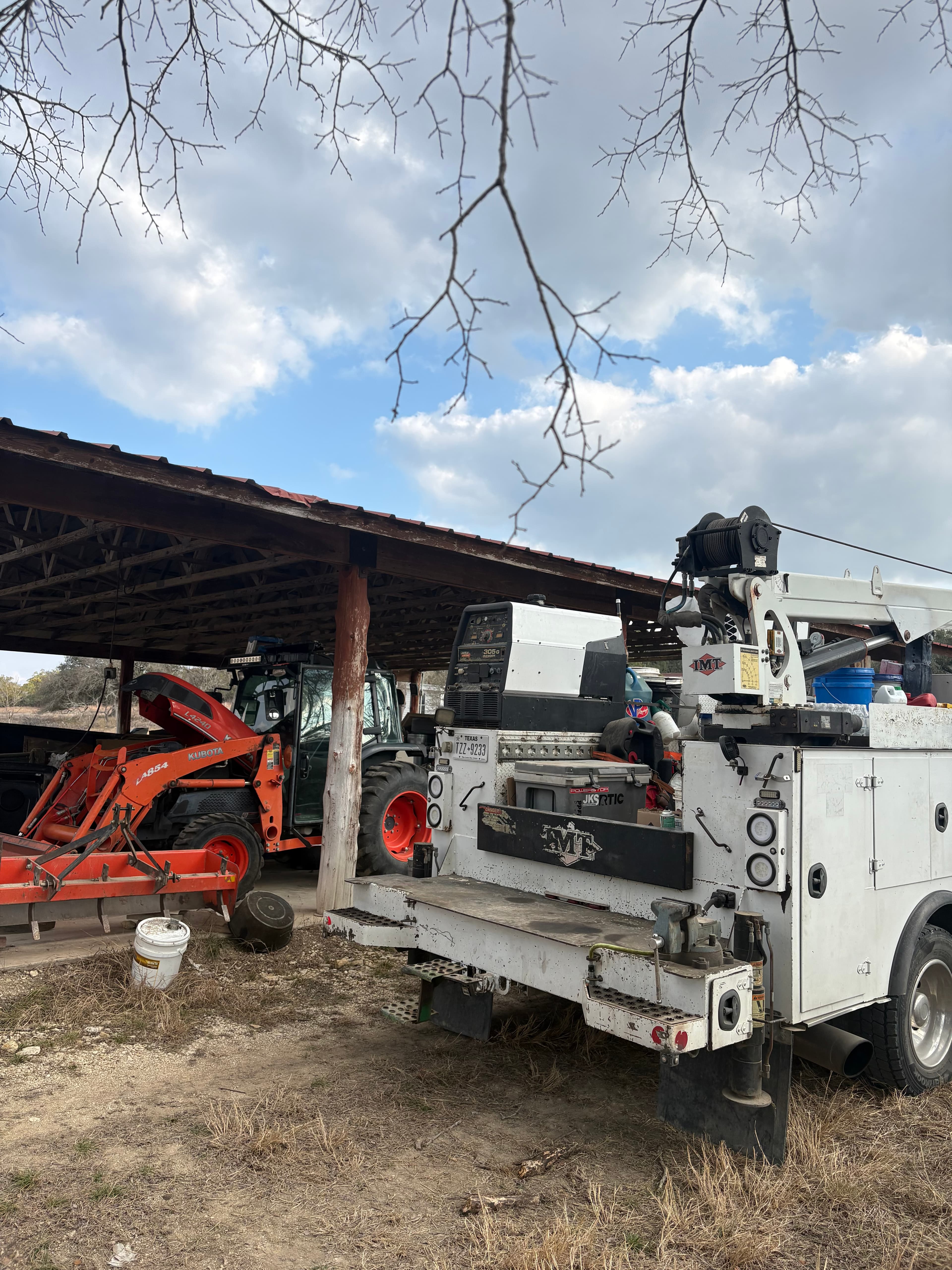 Service truck with crane arm deployed next to equipment